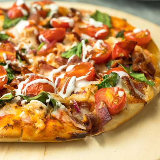 A freshly baked pizza with tomatoes, green peppers, and onions.