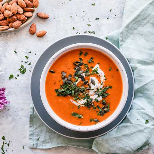 A tomato soup garnished with creme fraiche and chives.
